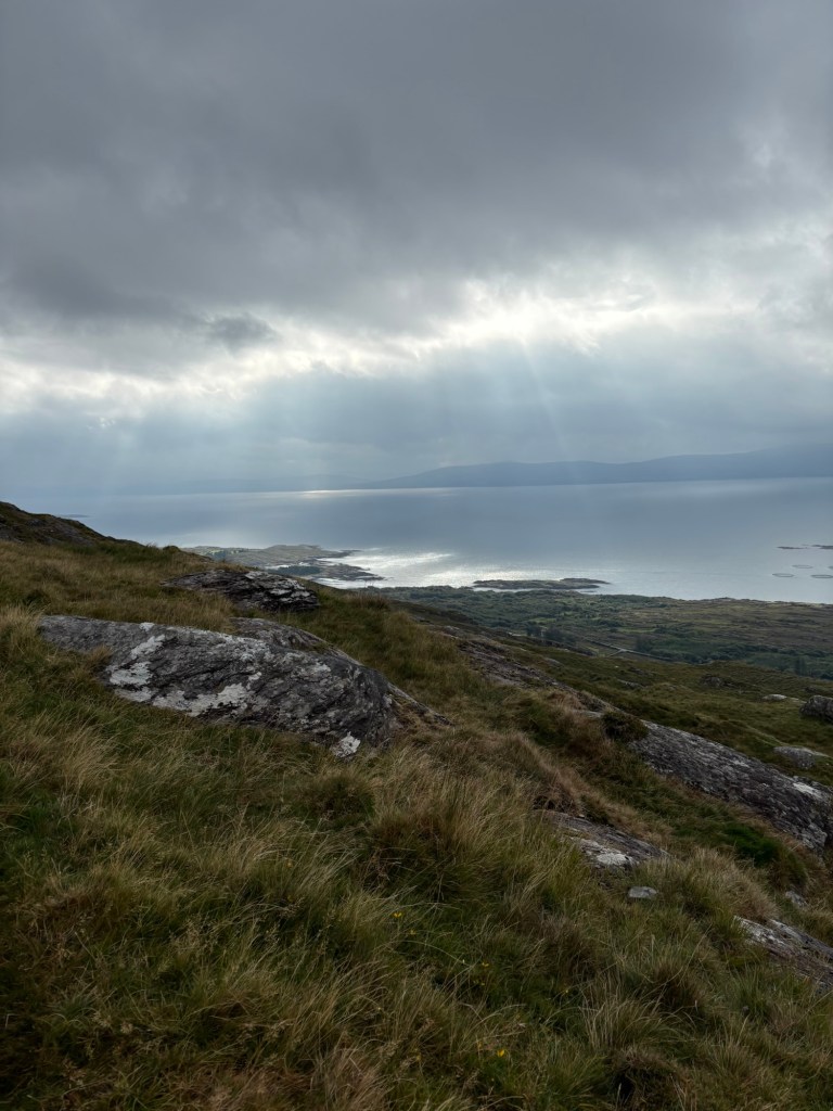 Sunbeams shining on water beneath dark clouds